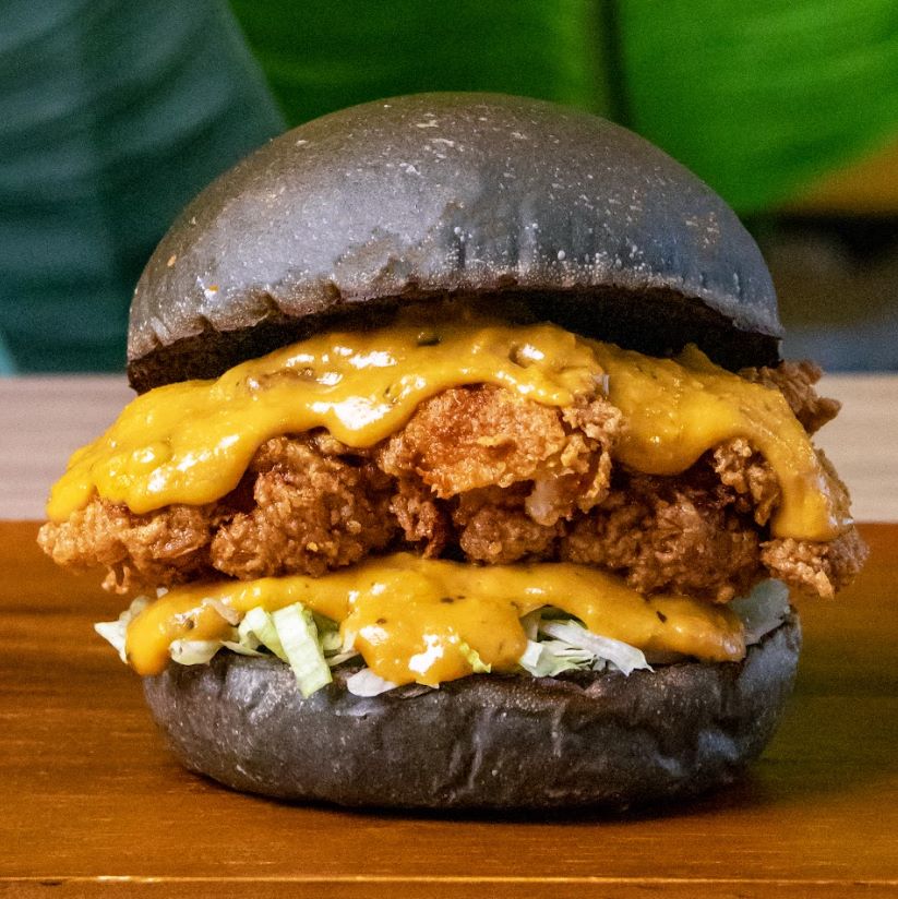 The SEY Burger, inspired by the 2016 Salted Egg Yolk Croissant craze, features a sauce made from salted duck egg, butter, garlic, curry leaves, chili, milk, and cream. This burger, a response to a viral trend, quickly became a social media sensation, showcasing a unique, localized twist on the chicken burger.