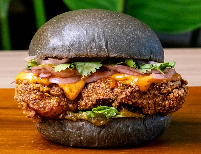 Our "Budu Budu! Burger" is a tribute to Kelantanese flavors, featuring a blend of Budu and mayo, enriched with local herbs and spices, slathered over a fried chicken thigh. Accompanied by cilantro, green chili relish, Asam Boi sweet onions, and shredded lettuce, it's a true celebration of Malaysian flavors.